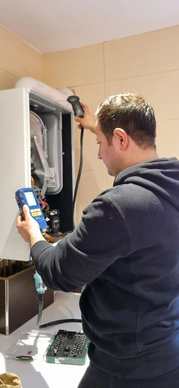 Engineer testing a boiler with a flue gas analyser